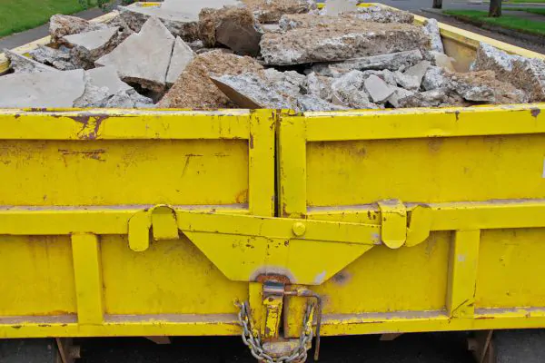 yellow dumpster full of concrete