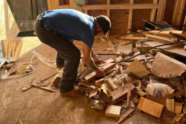 man compressing the wood for disposing